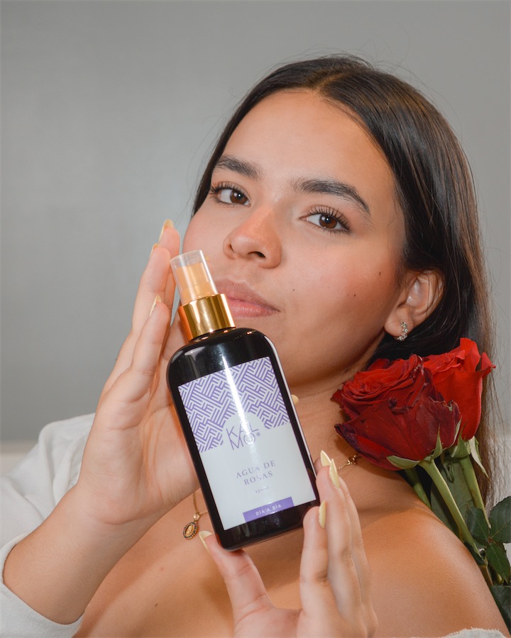Mujer con el Agua de Rosas Kalmo y un ramo de rosas