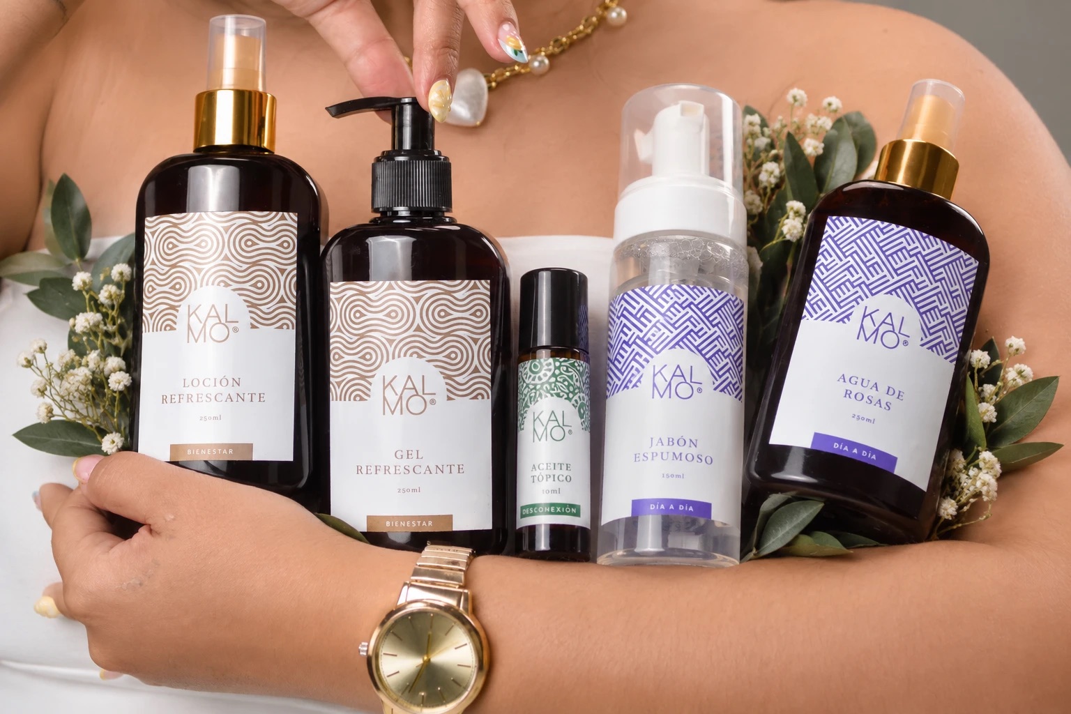 Los cinco productos del Kit Kalmo en brazos, entre flores
